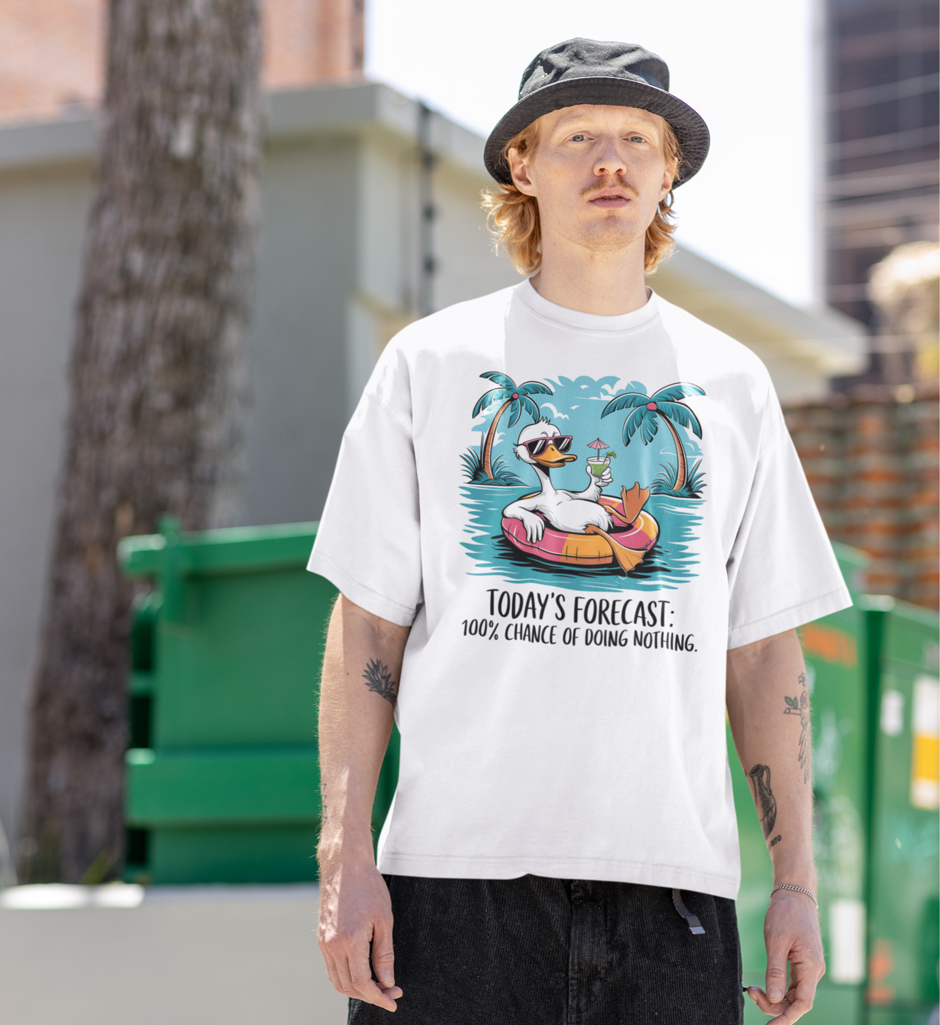 Νεαρός άνδρας με bucket καπέλο φοράει λευκό t-shirt με σχέδιο πάπιας και την φράση “Today’s Forecast: 100% Chance of Doing Nothing”