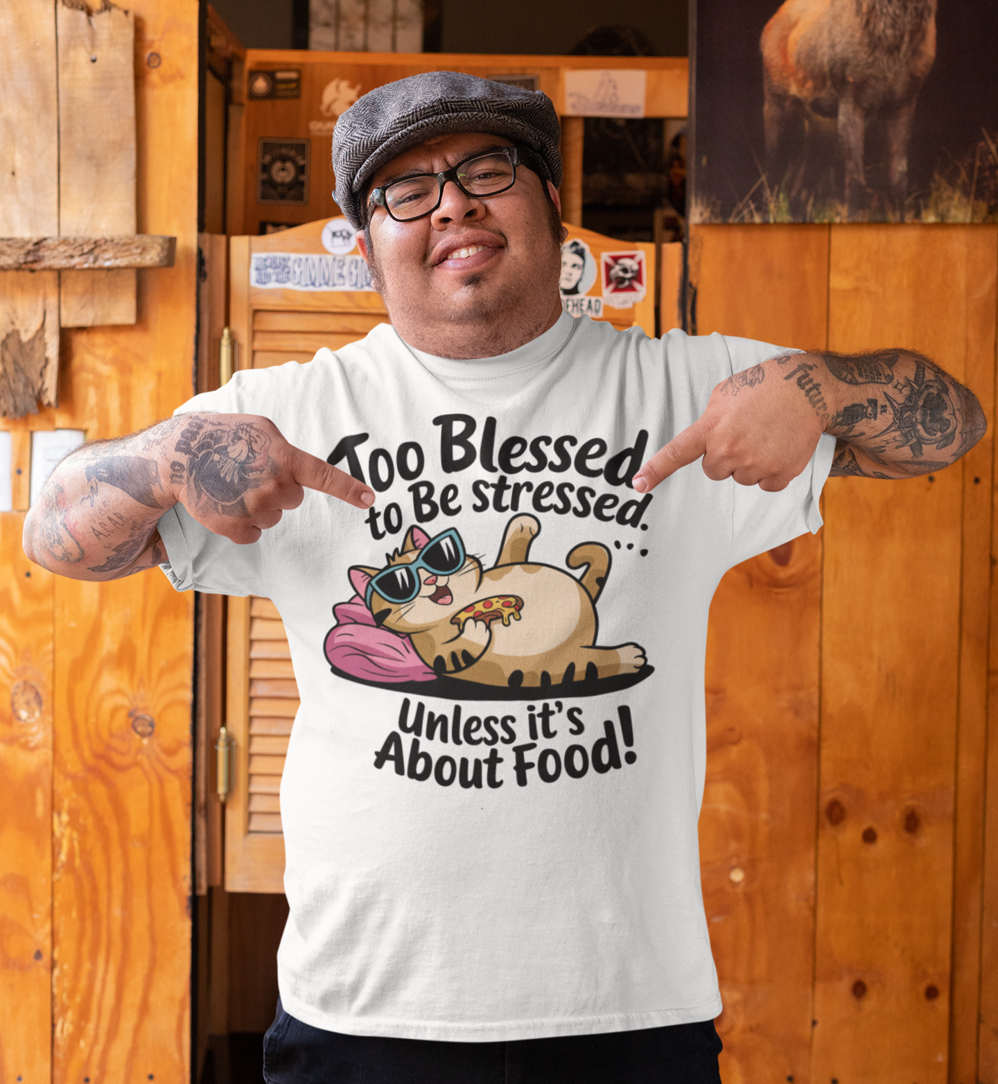 Άντρας με λευκό t-shirt που δείχνει γάτα ξαπλωμένη με πίτσα και το μήνυμα “Too Blessed to Be Stressed Unless It’s About Food”