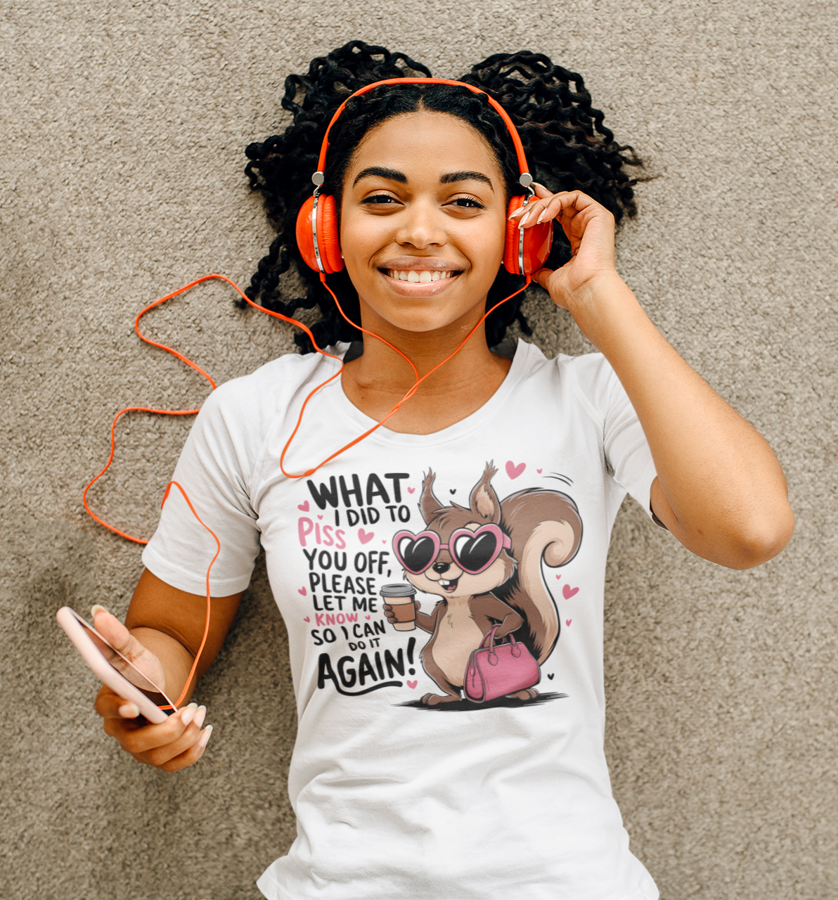 Γυναίκα ξαπλωμένη στο πάτωμα με ακουστικά και λευκό t-shirt με σκίουρο και τη φράση “What I Did to Piss You Off… Let Me Know So I Can Do It Again!”