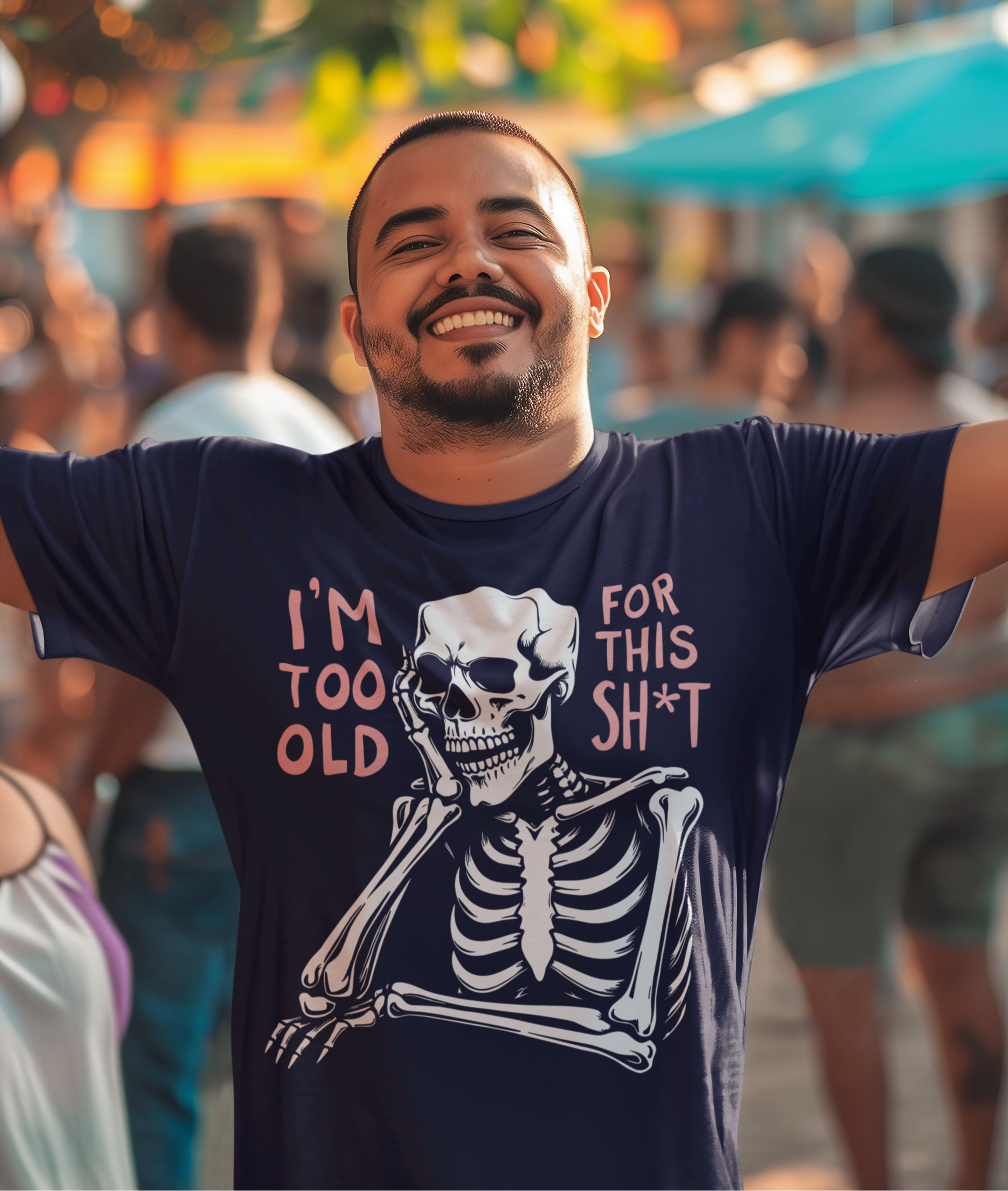 Χαμογελαστός άντρας με ναυτικό μπλε μπλουζάκι που γράφει “I’m too old for this sh*t” και δείχνει έναν σκελετό σε βαριεστημένη πόζα.