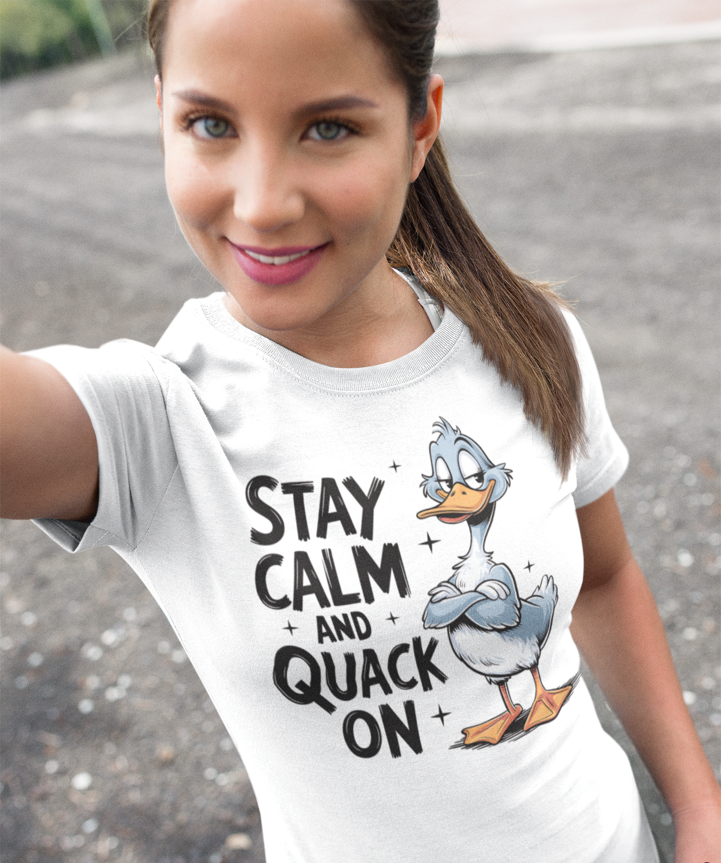 Γυναίκα φοράει λευκό t-shirt με τύπωμα "Stay Calm and Quack On" και σχέδιο πάπιας, selfie σε εξωτερικό χώρο