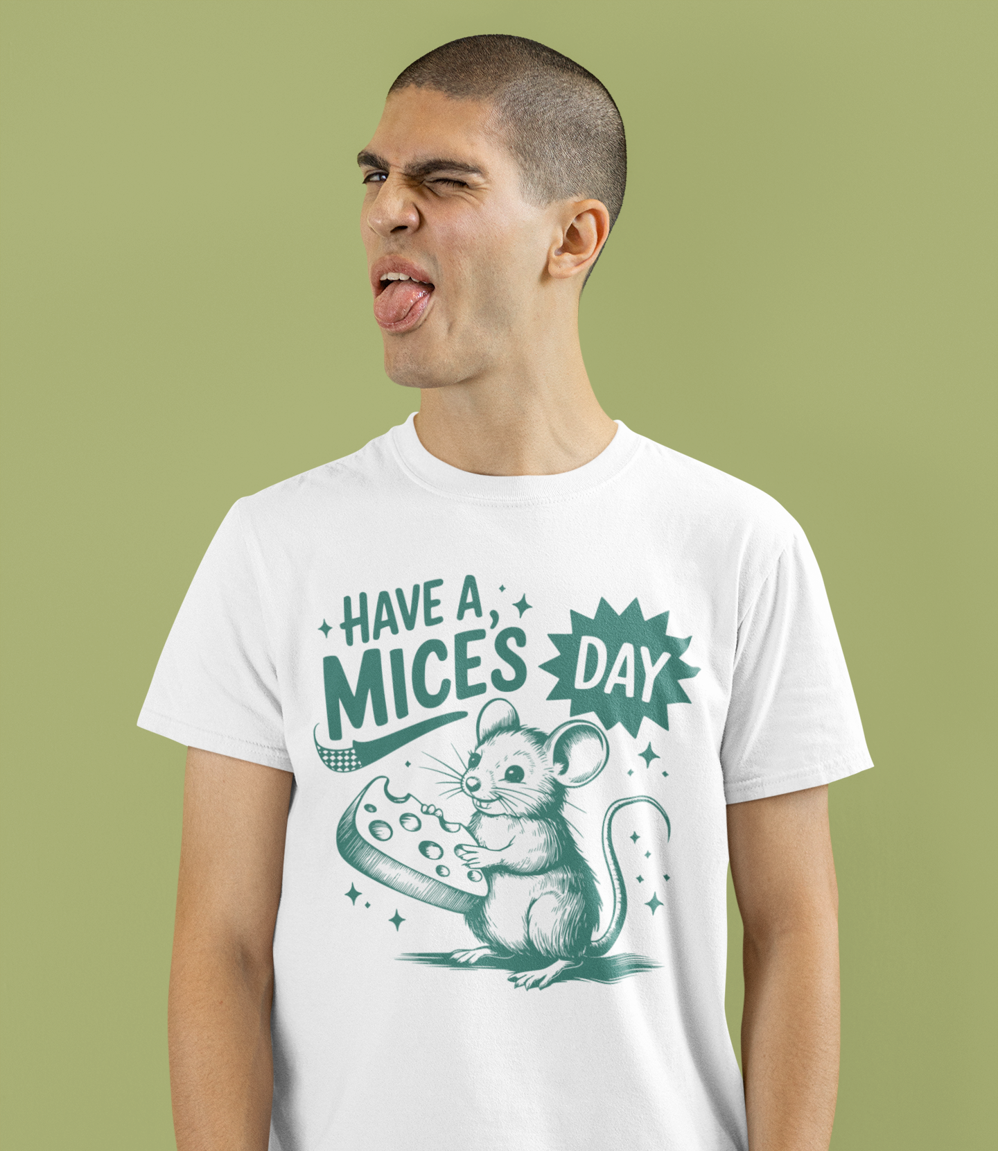 Άντρας με λευκό μπλουζάκι "Have a Mice’s Day" με ποντίκι και τυρί, κάνει αστεία γκριμάτσα μπροστά σε πράσινο φόντο.