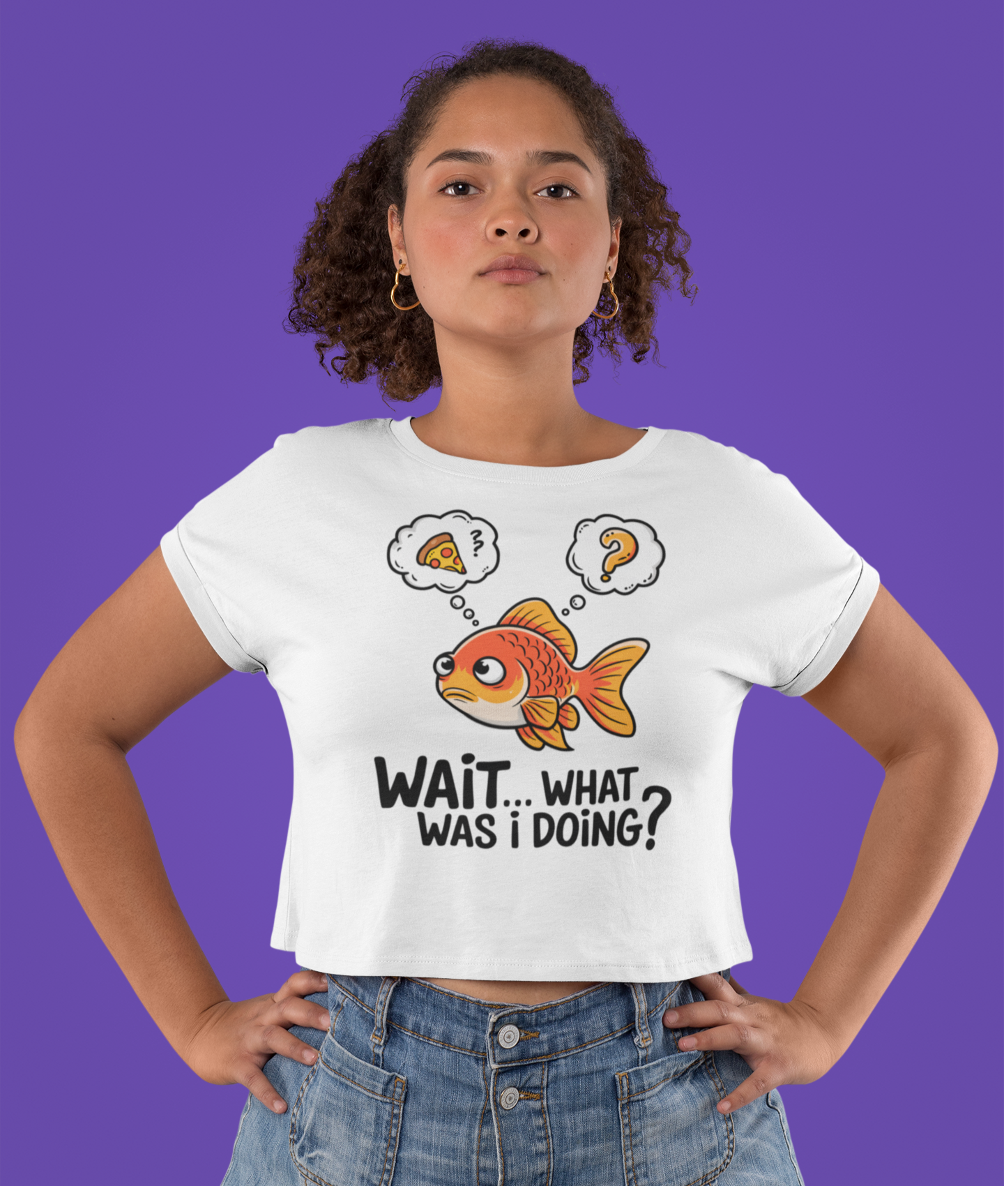 Γυναίκα φοράει λευκό crop top με χρυσόψαρο και φούσκες σκέψης, μπροστά σε μοβ φόντο