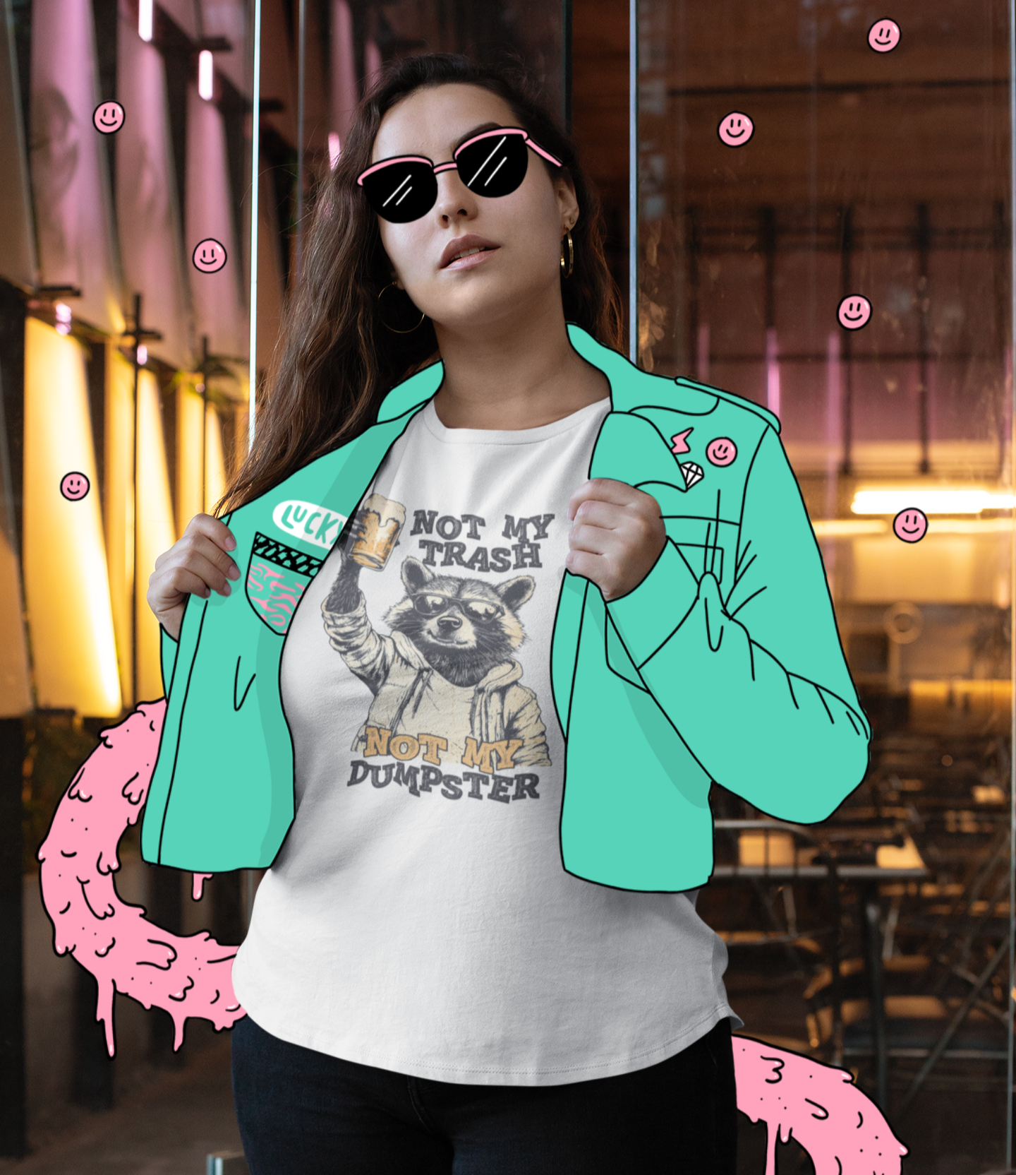 Γυναίκα φοράει λευκό t-shirt με ρακούν και το χιουμοριστικό μήνυμα “Not My Trash, Not My Dumpster” μπροστά από εσωτερικό χώρο με graffiti-style εικονογράφηση