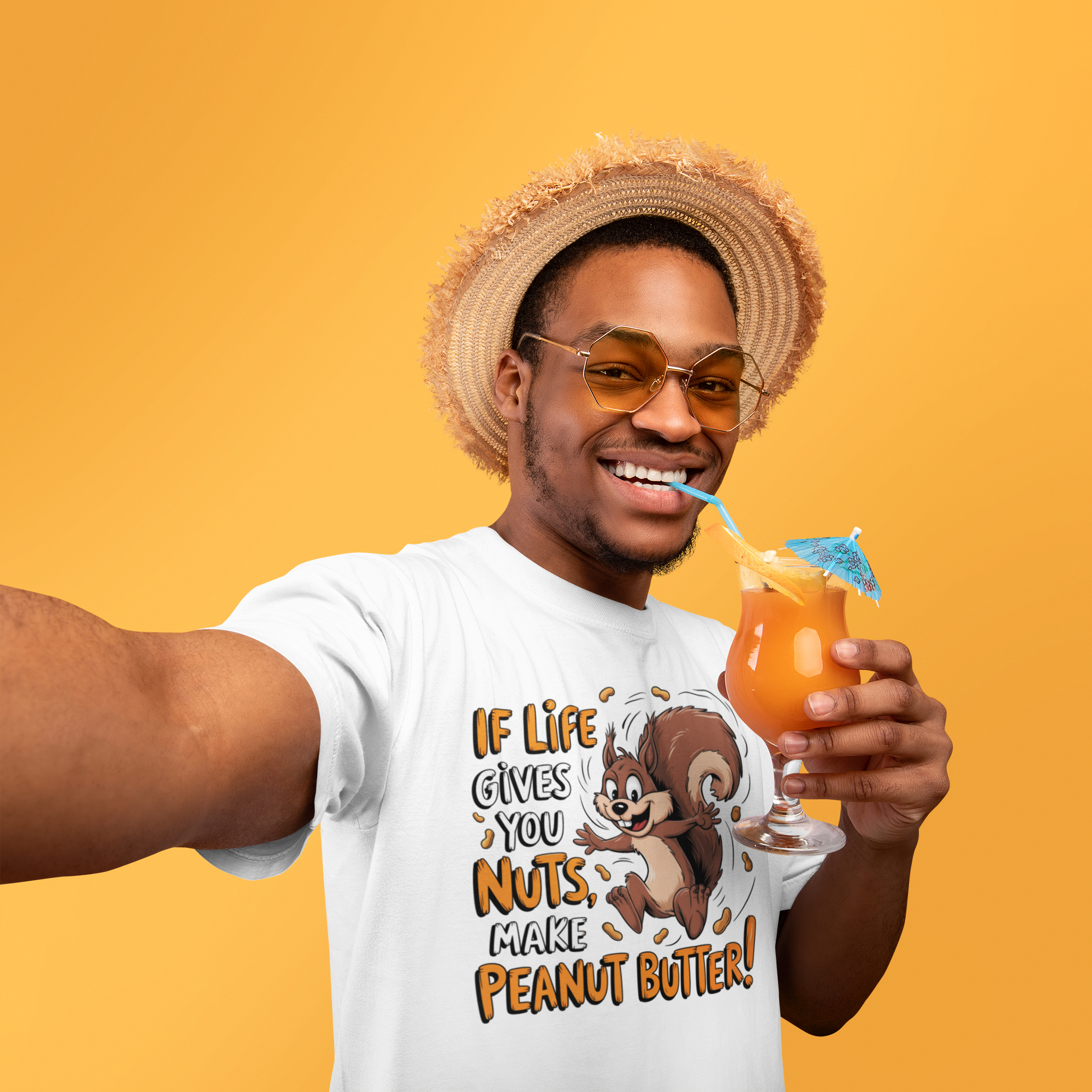 Χαμογελαστός άνδρας με καπέλο και ποτό, φοράει λευκό t-shirt με σκίουρο και φράση "If Life Gives You Nuts, Make Peanut Butter"
